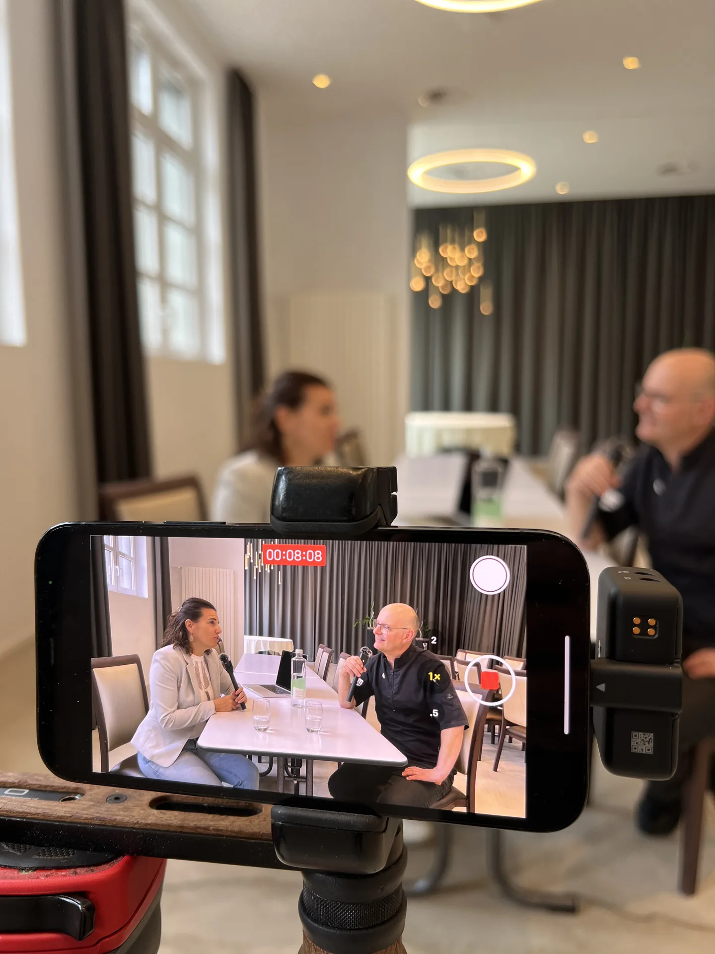 Smartphone-Display zeigt das laufende Podcast-Interview bei 00:08:08 Aufnahme